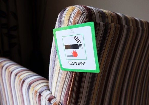 An image of a chair with a sticker highlighting that the material is fire resistant.  
