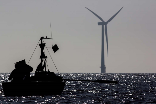 boat overlooking a wind turbine