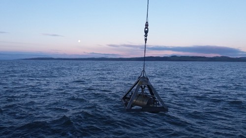 An image of a sediment day grab being deployed from a ship. 
